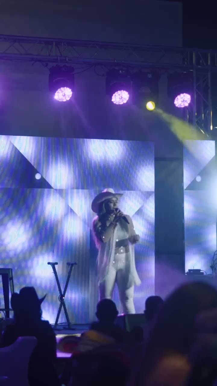 Valerie cantando en gran escenario con luces