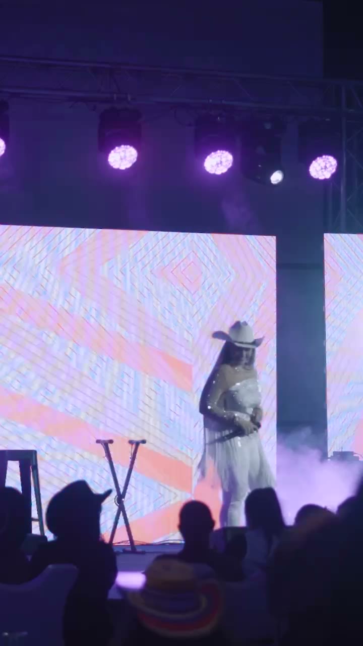 Valerie cantando en escenario con pantallas LED